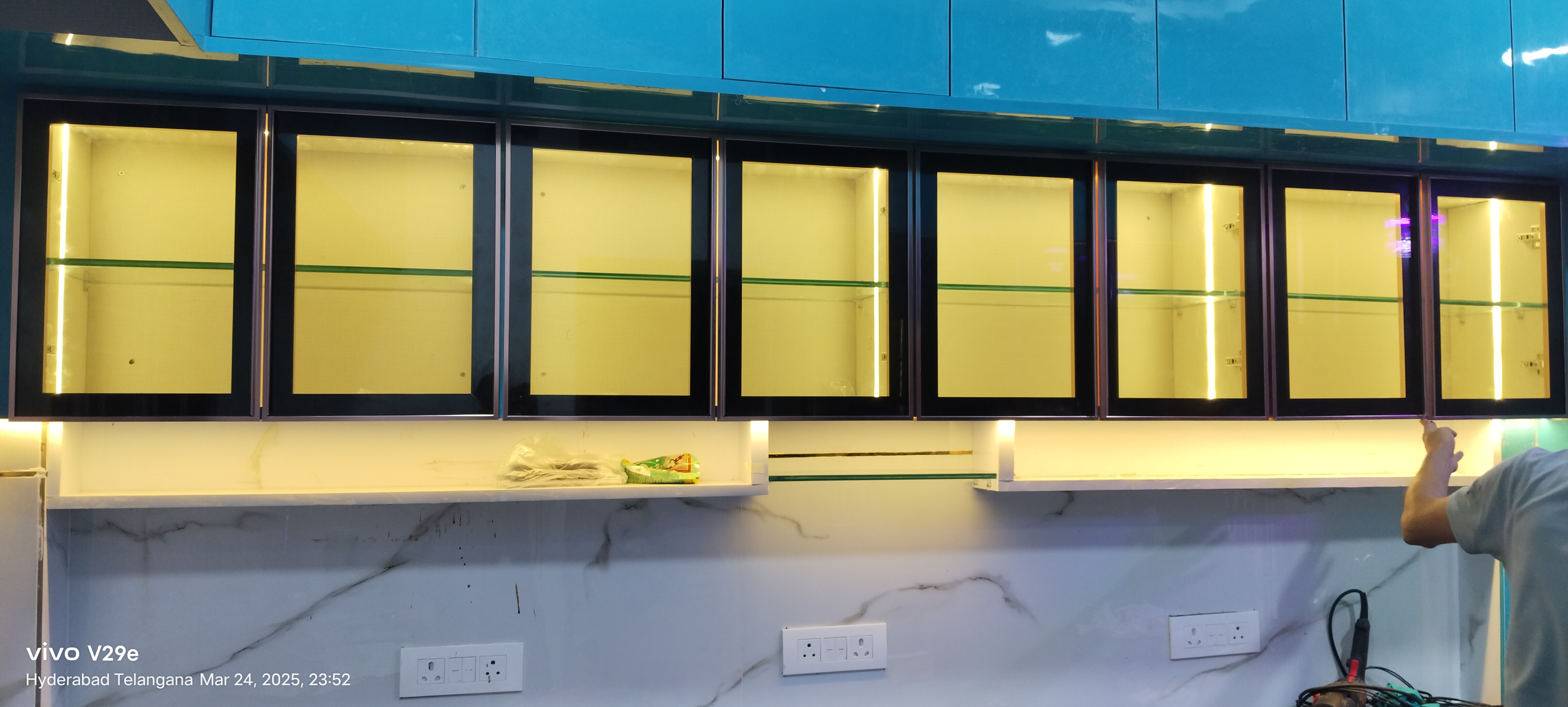 Long row of aluminium framed overhead kitchen cabinets