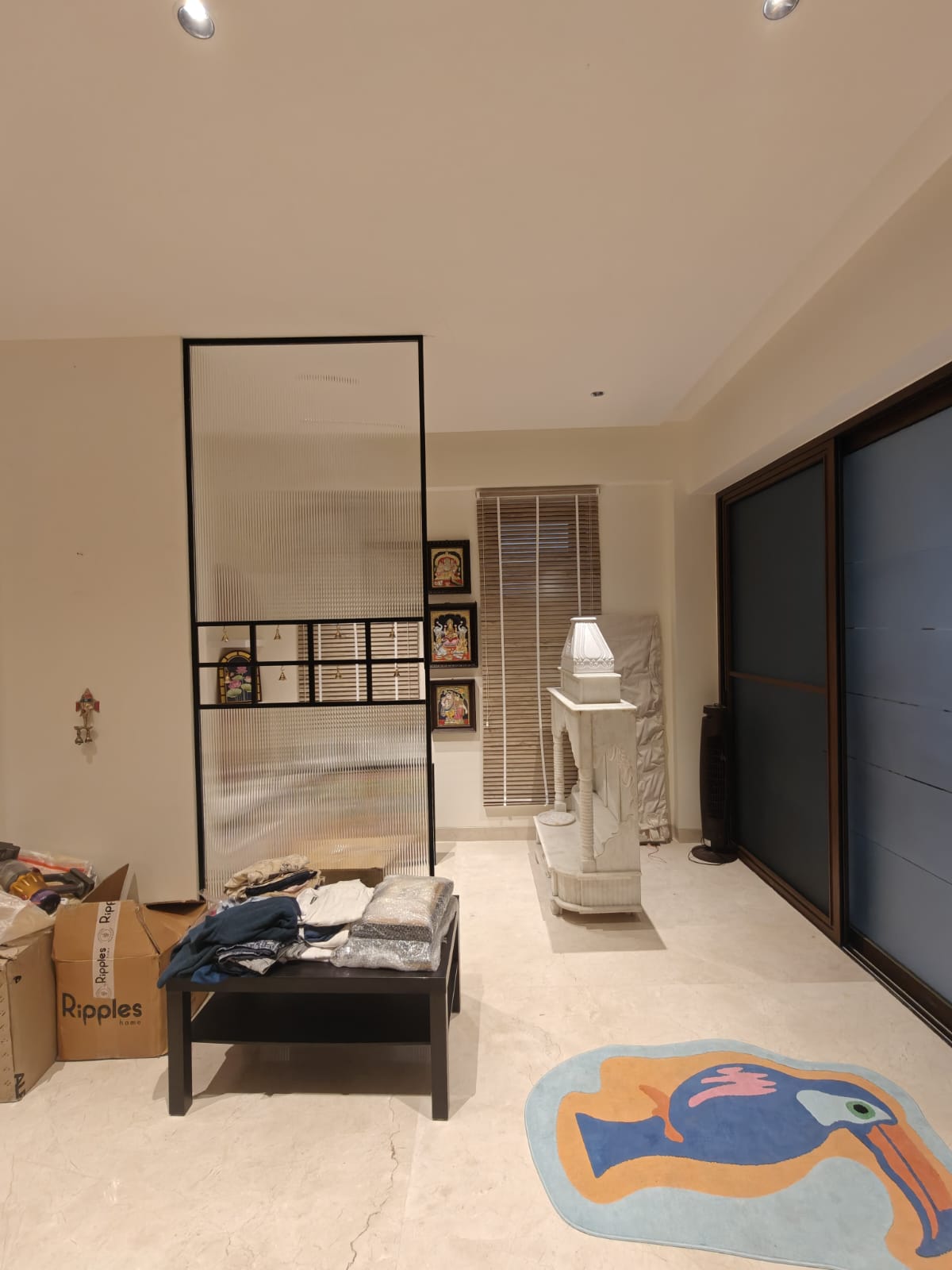 Slim black framed glass divider in a living room