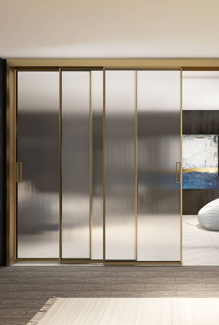 Floor-to-ceiling wardrobe with ribbed glass and gold frames
